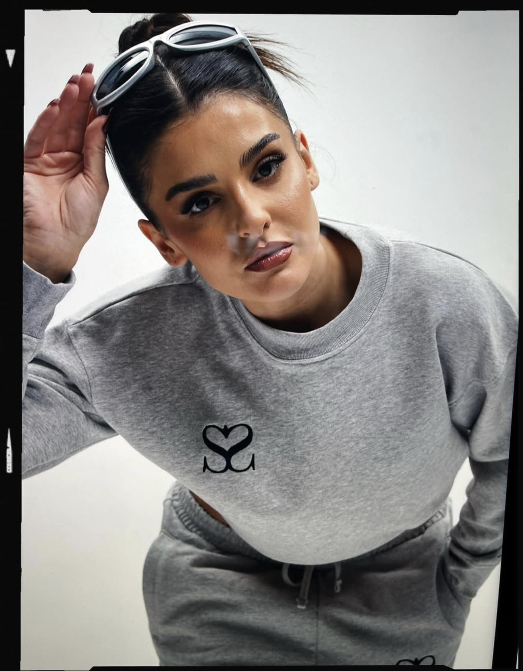 Fashionporträt in grauem Sweatshirt mit Sonnenbrille
